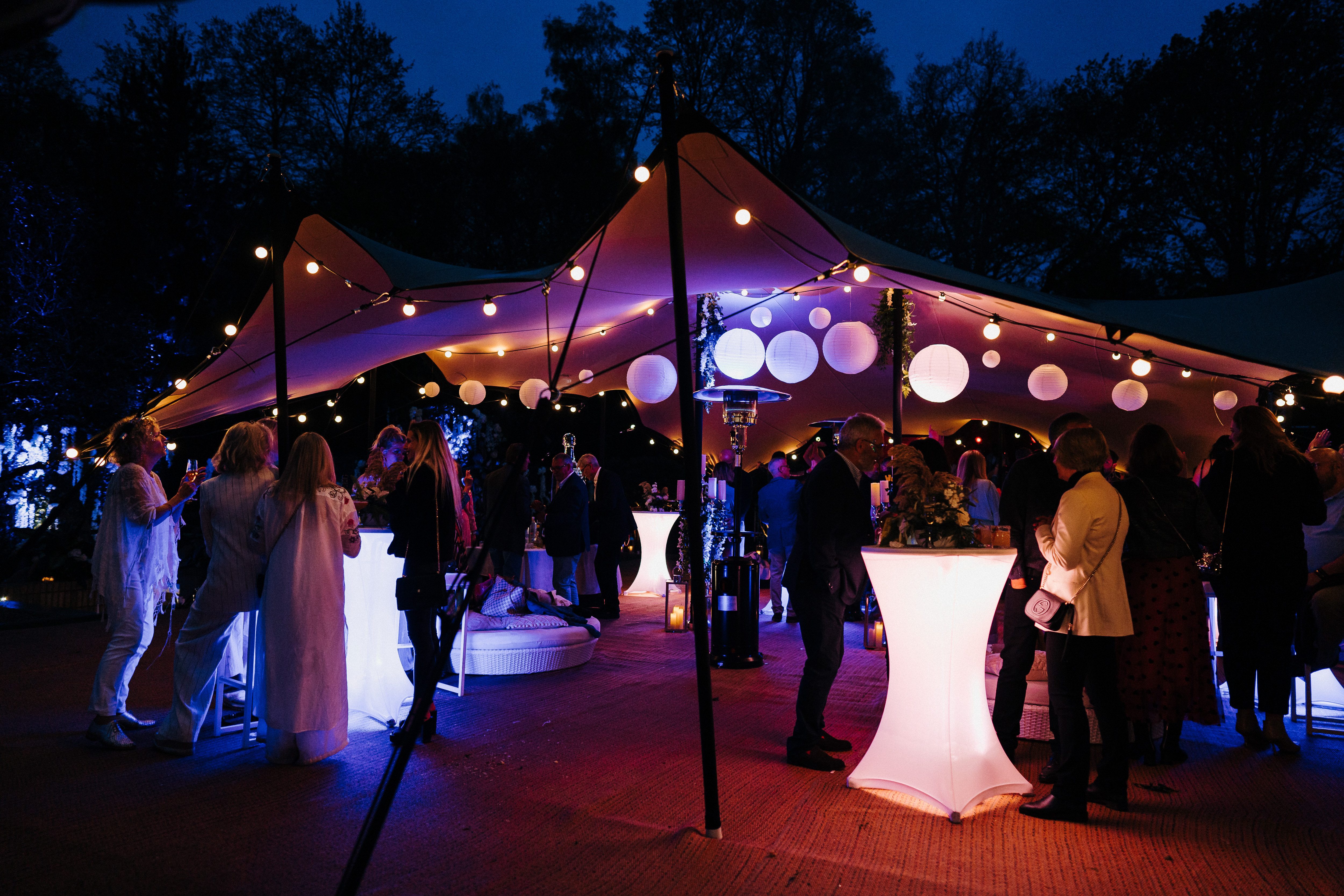 A group of people under a gazebo at night