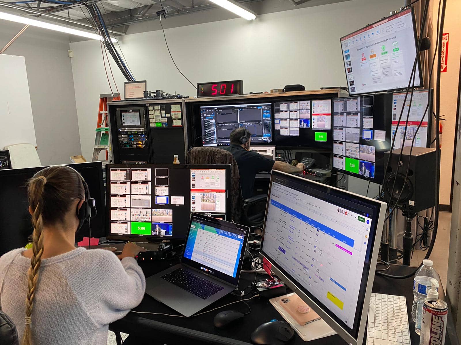 A person working in a room with multiple computers