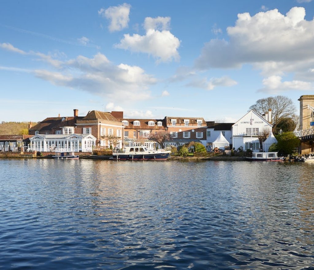 A body of water with a hotel and boat.
