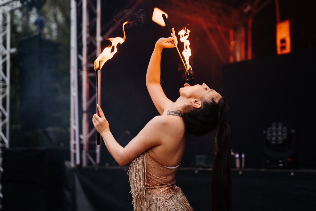 A person with firesticks in her mouth.