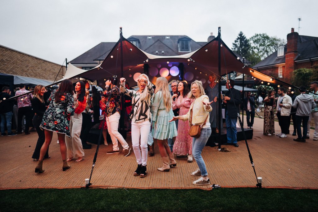 People dancing under a gazebo.