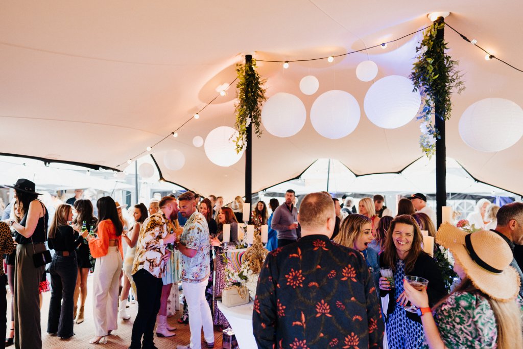 A group of people standing in a tent.