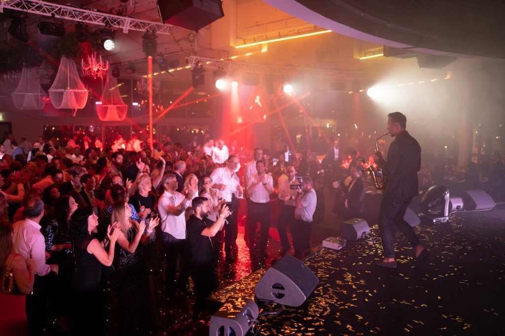 A person on stage with a crowd of people.