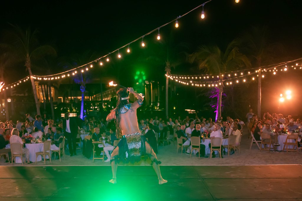 A person dancing on stage with a crowd of people around.